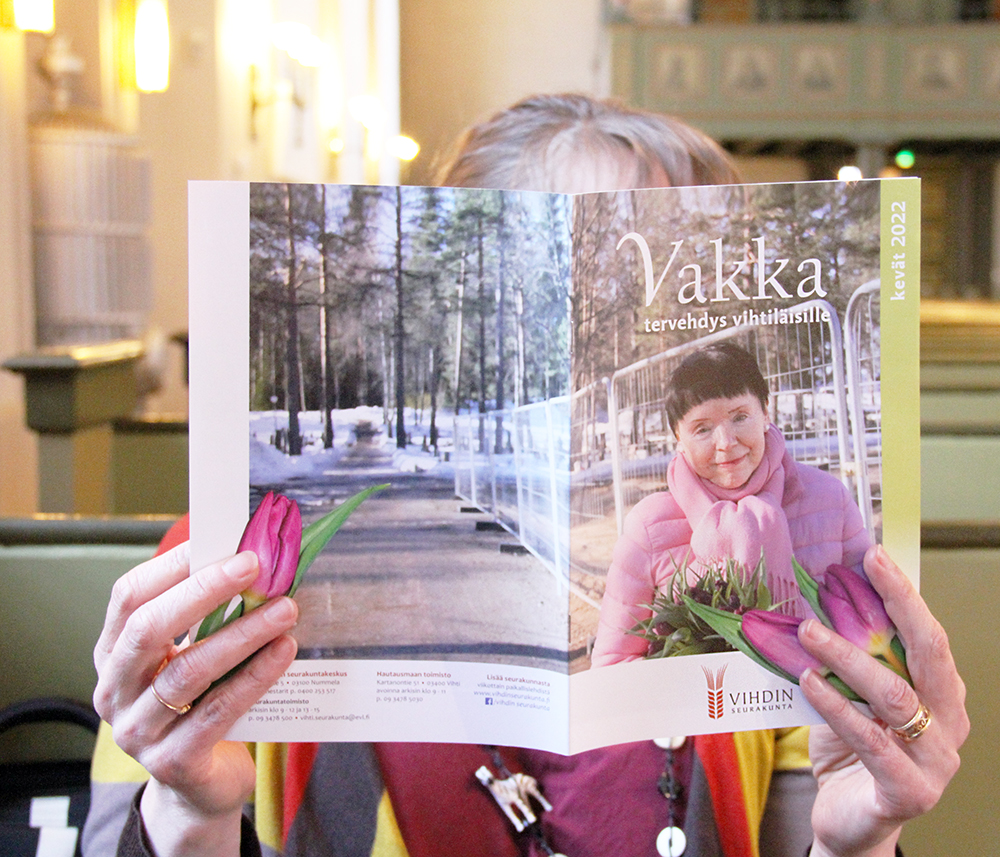 Kuvassa ihminen lukee Vihdin seurakunnan Vakka-lehteä.